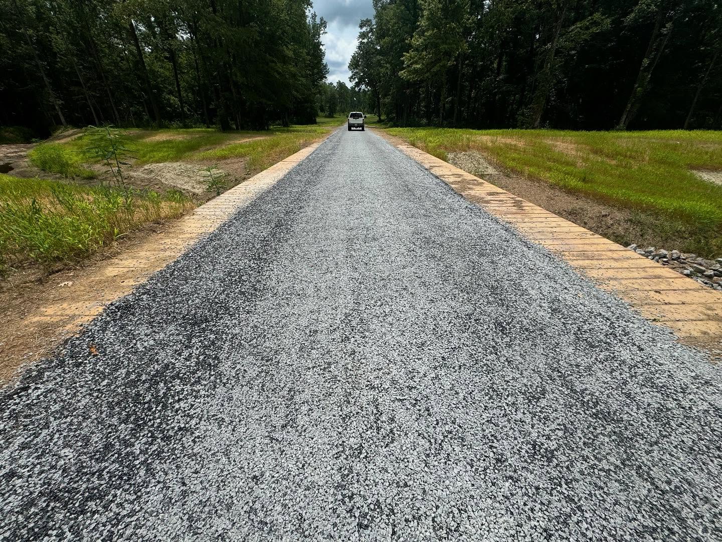 Gravel access road extending through a wooded property